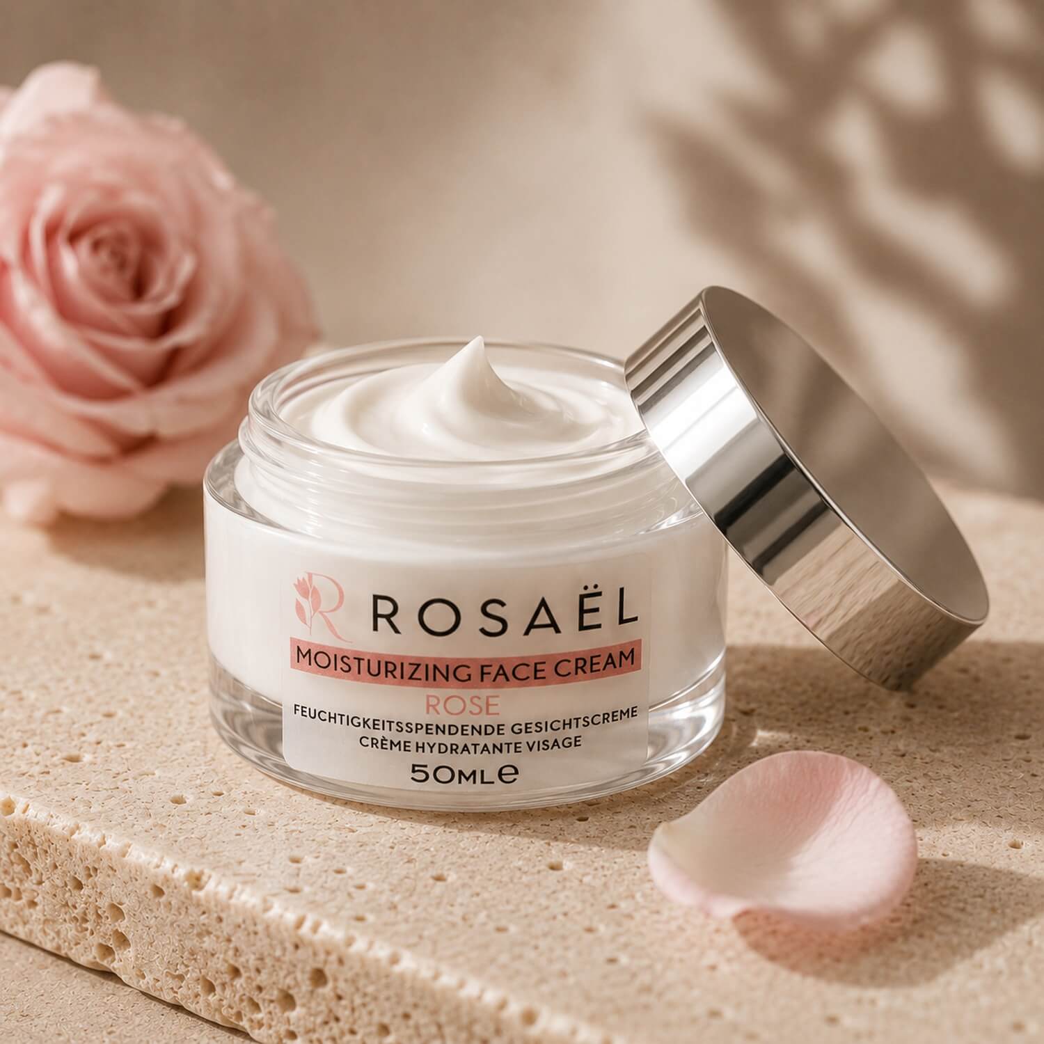 Offener Rosaël Gesichtscreme-Tiegel mit sichtbarer Creme und silbernem Deckel auf hellem Stein